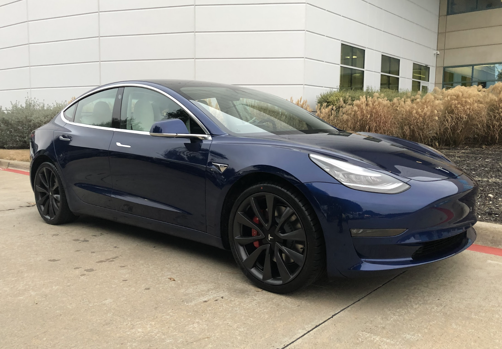 Keith's first Tesla, a deep blue Model 3, parked on a bright afternoon